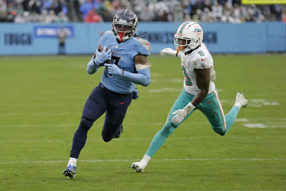Titans running back D'Onta Foreman gets past Dolphins free safety Jevon Holland on his way to a 21-yard touchdown run in the first half of Sunday's game in Nashville.