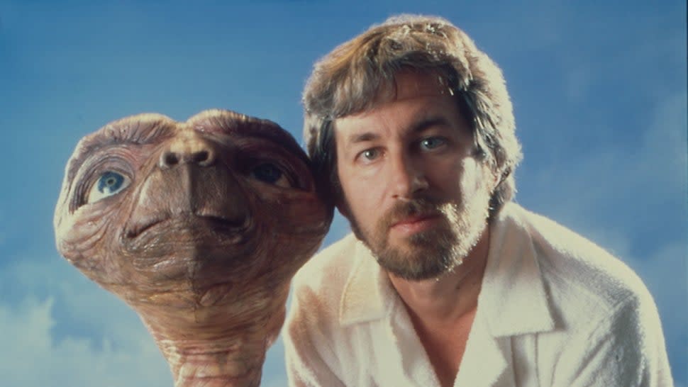 A promotional image of Steven Spielberg posing with E.T.