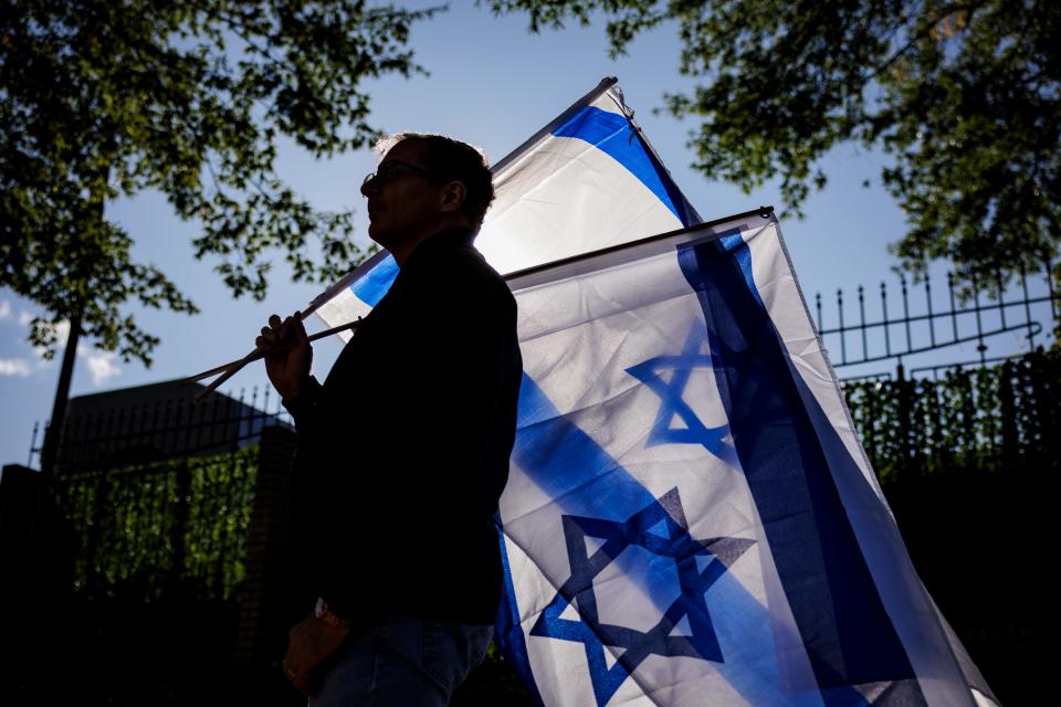 A man carries two Israeli flags during a pro-Israel rally outside of Israeli Embassy on Oct. 8, 2023 in Washington, DC.