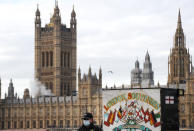 A man walks past a souvenir shop opposite the Houses of Parliament during the debate in the House of Commons on the EU (Future Relationship) Bill in London, Wednesday, Dec. 30, 2020. The European Union's top officials have formally signed the post-Brexit trade deal with the United Kingdom, as lawmakers in London get set to vote on the agreement. (AP Photo/Frank Augstein)
