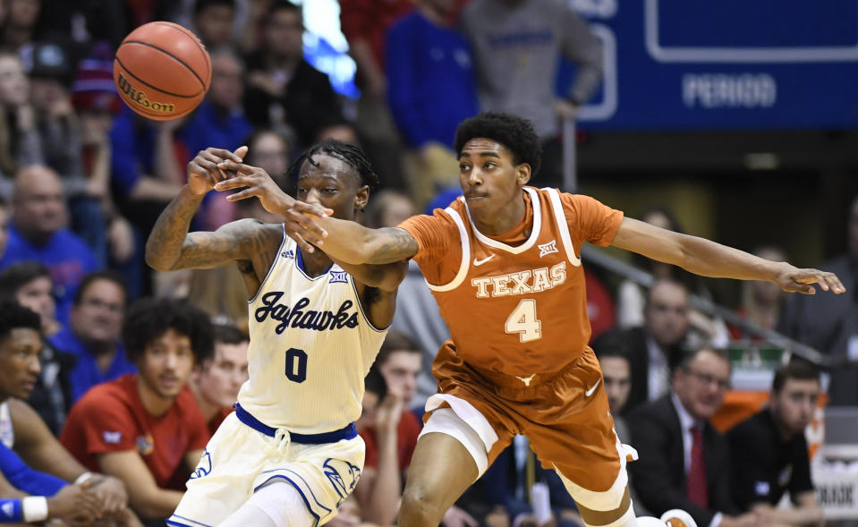 Texas guard Donovan Williams (4) steals the ball from Kansas guard Marcus Garrett (0) during the second half of an NCAA college basketball game in Lawrence, Kan., Monday, Feb. 3, 2020. (AP Photo/Reed Hoffmann)