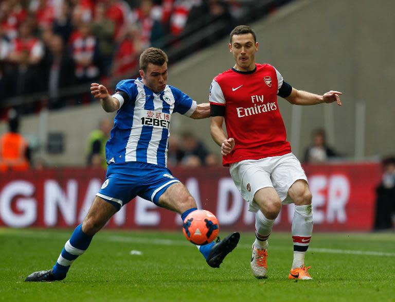 Arsenal's Thomas Vermaelen (L) fights for the ball with Wigan Athletic's Callum McManaman during their English FA Cup semi-final match, at Wembley Stadium in London, on April 12, 2014