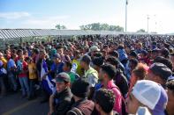 Migrants, part of a caravan travelling to the U.S., stand at the border between Guatemala and Mexico