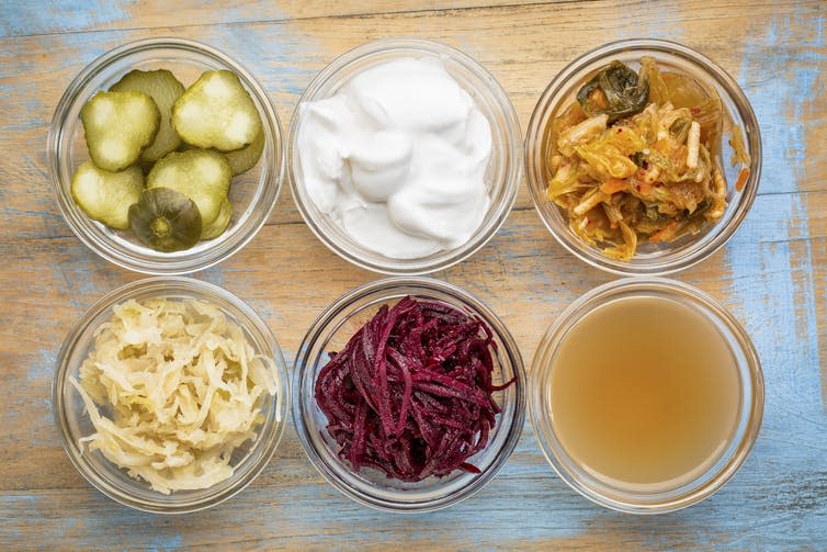 Small glass pots filled with different probiotic foods, such as yoghurt and sauerkraut.