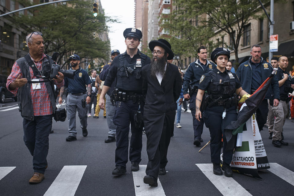 Police escort a pro-Palestinian ultra-Orthodox Jewish demonstrator after detaining him near the Metropolitan Museum of Art where the Met Gala is being held, Monday, May 6, 2024, in New York. (AP Photo/Andres Kudacki)