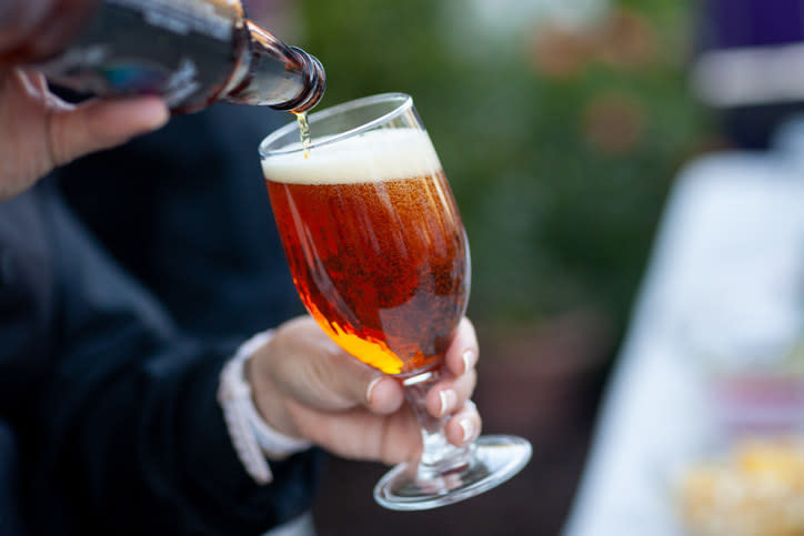 person pouring beer into a glass