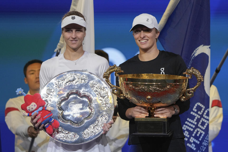 Winner Iga Swiatek of Poland, right, holds her trophy poses with runner up Liudmila Samsanova of Russia during the awards ceremony for the women's singles final match in the China Open tennis tournament at the Diamond Court in Beijing, Sunday, Oct. 8, 2023. (AP Photo/Andy Wong)