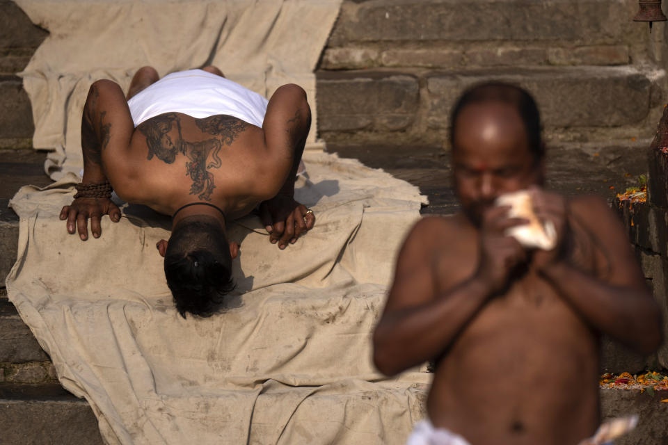 A Nepalese Hindu devotee prostrates on the ground outside a temple as part of performing a ritual during Madhav Narayan festival in Bhaktapur, Nepal, Thursday, Jan. 25, 2024. (AP Photo/Niranjan Shrestha)