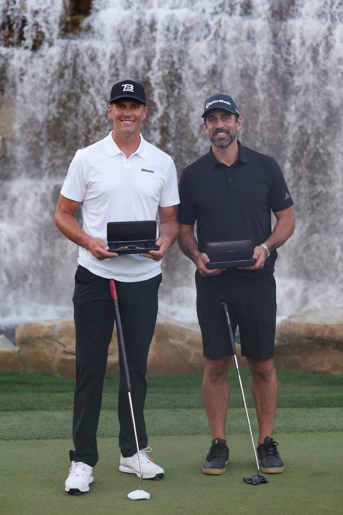 NFL quarterback Tom Brady and Aaron Rodgers celebrate winning The Match VI against Josh Allen and Patrick Mahomes at Wynn Golf Club in Las Vegas.