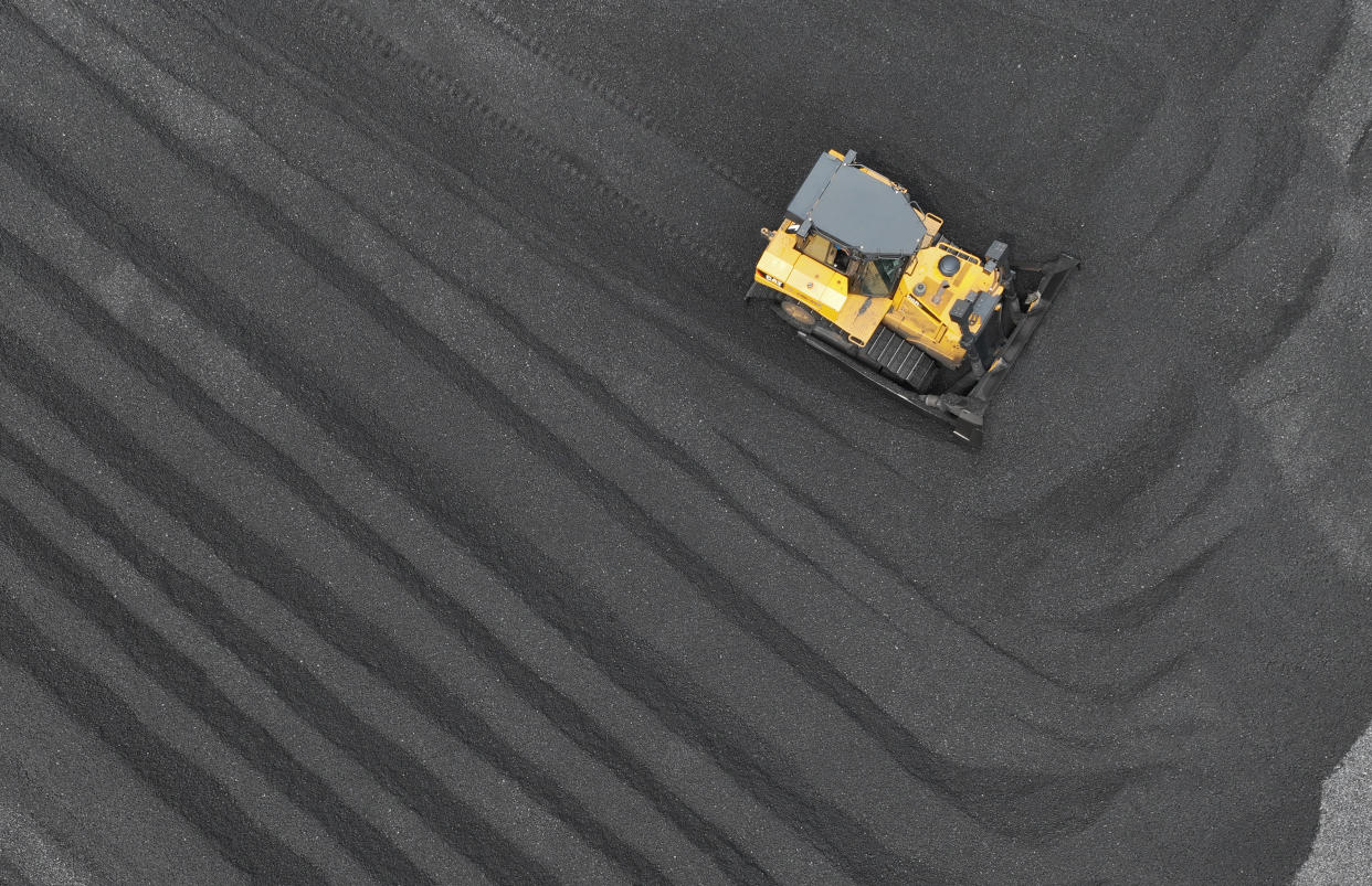 A bulldozer moves piles of coal in Lianyungang, China