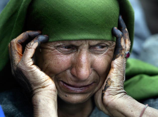 A Kashmiri Muslim woman, with henna on her hands, grieves during the funeral procession of Indian Army soldier Shabir Ahmed Malik in Dab, some 35 kilometers (22 miles) Northeast of Srinagar, India, Tuesday, March 24, 2009. Malik was killed in an ongoing battle which has claimed seven other army soldiers and sixteen suspected rebels, Lt. Col. J.S. Brar of the Indian Army said. (AP Photo/Dar Yasin)