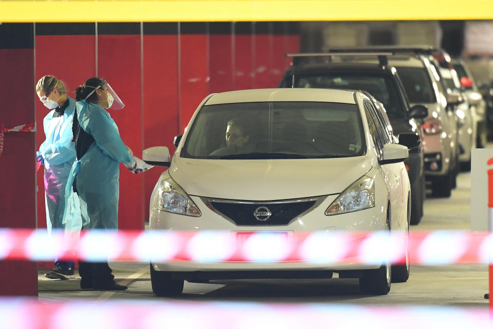 Healthcare employees are seen at work in a COVID-19 testing facility at Northland Shopping Centre in Melbourne. Source: AAP