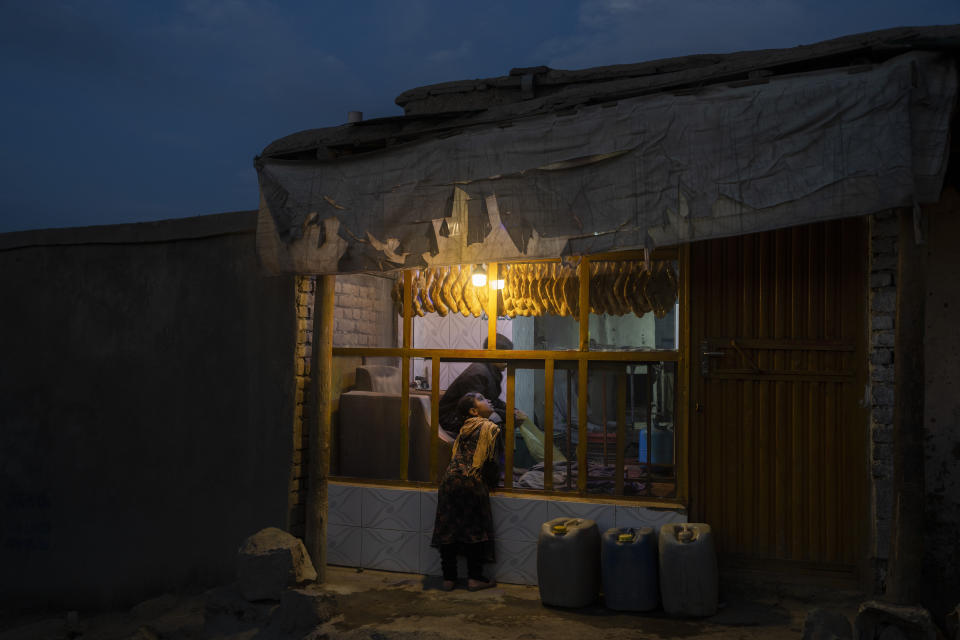 A young girl looks at loaves of bread for sale at a bakery, in Kabul, Afghanistan, Wednesday, Nov. 17, 2021. (AP Photo/Petros Giannakouris)