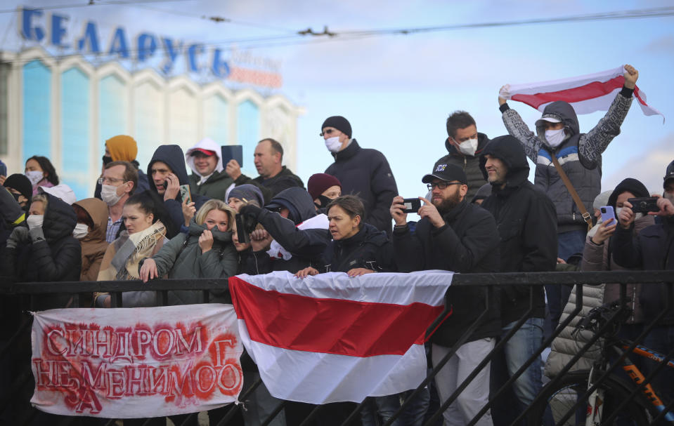 People with old Belarusian national flags attend an opposition rally to protest the official presidential election results in Minsk, Belarus, Sunday, Oct. 18, 2020. Tens of thousands rallied in Minsk once again on Sunday, demanding the resignation of the country's authoritarian leader. Mass weekend protests in the Belarusian capital have continued since Aug. 9, when officials handed President Alexander Lukashenko a landslide victory in an election widely seen as rigged. (AP Photo)