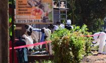 Ugandan explosives experts inspect the debris at the scene of an explosion in Komamboga, on the northern outskirts of Kampala