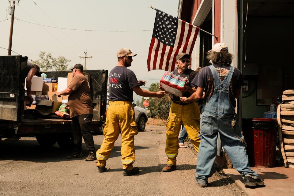 Volunteers haul in supplies to the fire station situated on Nelson Street to serve residents that defied evacuation orders on August 8, 2021 in Taylorsville, California. The Dixie Fire, which has incinerated more than 463,000 acres, is the one of the largest recorded wildfires in state history and remains only 21 percent contained. 