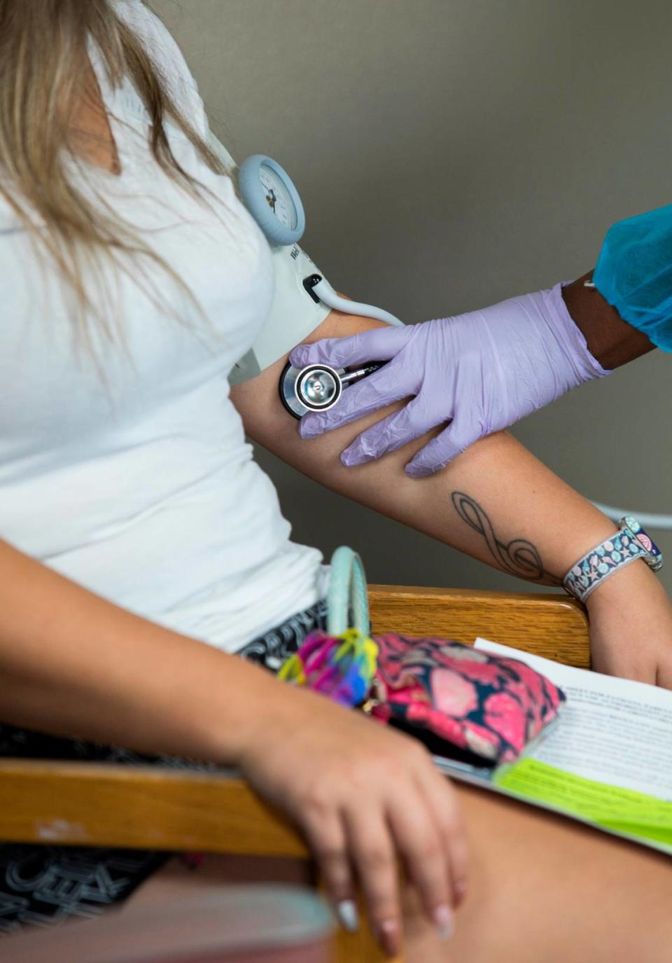 Emmily Mangum has her blood pressure taken by Talia Roofe after receiving monoclonal antibody treatment for COVID-19 at a clinic in the Johnston County Public Health Department parking lot in Smithfield, N.C. on Wednesday, Sept. 15, 2021.