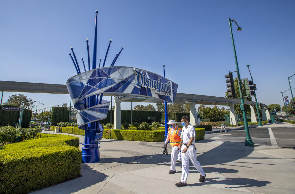 ANAHEIM, CA - SEPTEMBER 30: Employees walk past the entrance to Disneyland Park on Wednesday, Sept. 30, 2020 in Anaheim, CA. After suffering losses for months due to Gov. Newsoms mandatory coronavirus shut-down, Disney says it will lay off 28,000 employees across its parks, experiences and consumer products segment.(Allen J. Schaben / Los Angeles Times via Getty Images)