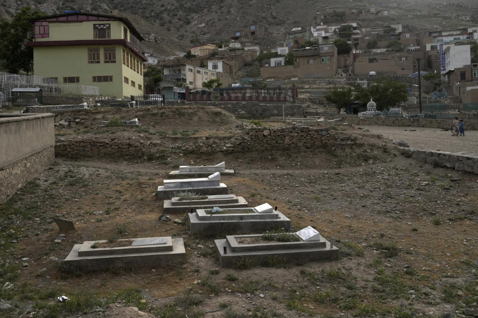A view of a cemetery next to houses in Kabul, Afghanistan, Monday, May 9, 2022. There are cemeteries all over Afghanistan's capital, Kabul, many of them filled with the dead from the country's decades of war. They are incorporated casually into Afghans' lives. They provide open spaces where children play football or cricket or fly kites, where adults hang out, smoking, talking and joking, since there are few public parks. (AP Photo/Ebrahim Noroozi)