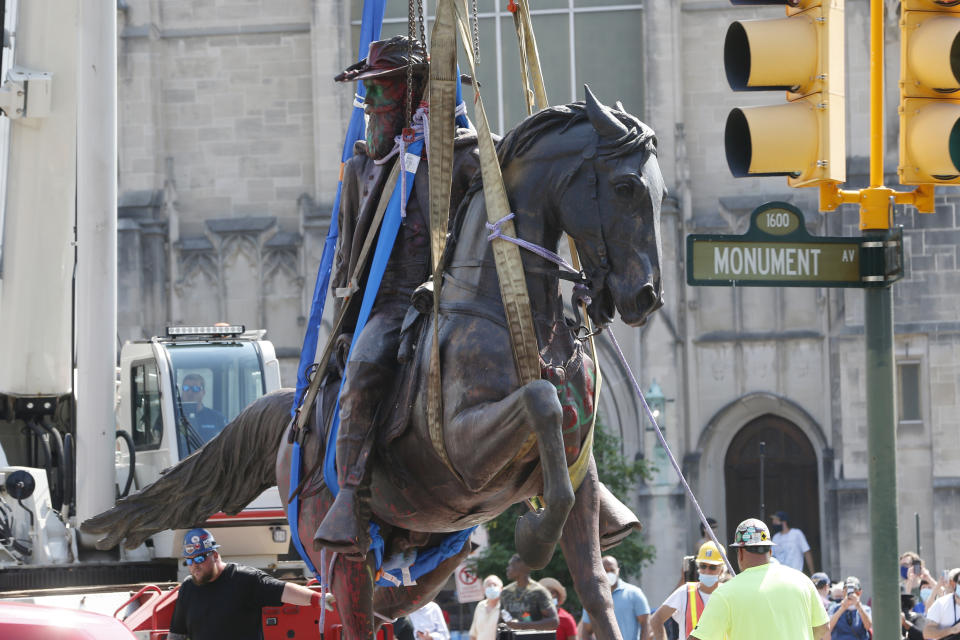 Crews lower the statue Confederate General J.E.B. Stuart after removing it from its pedestal on Monument Avenue, Tuesday, July 7, 2020, in Richmond, Va. The statue is one of several that will be removed by the city as part of the Black Lives Matter reaction. (AP Photo/Steve Helber)