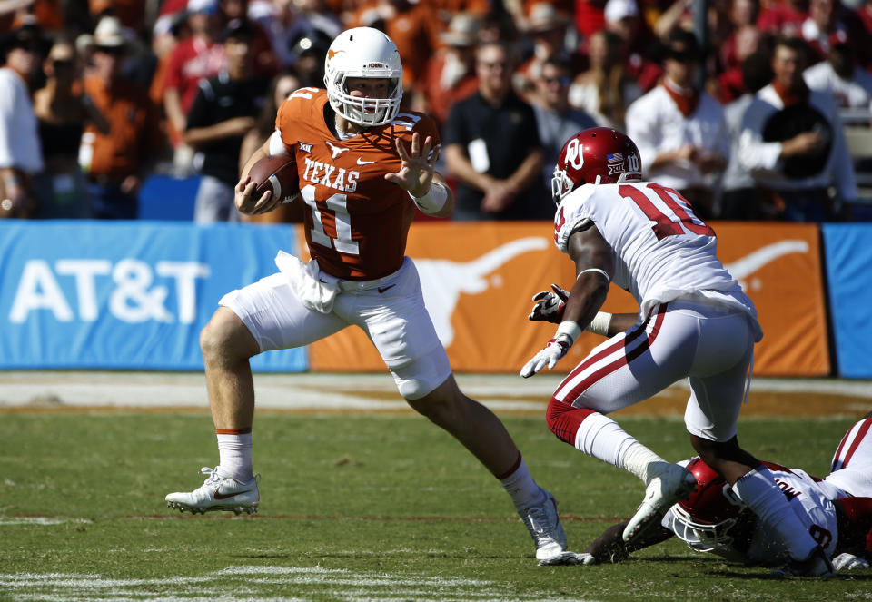 Texas quarterback Sam Ehlinger (11) tries to get past Oklahoma linebacker Kenneth Murray (9) and cornerback Parnell Motley (11) during the first half of an NCAA college football game Saturday, Oct. 14, 2017, in Dallas. (AP Photo/Ron Jenkins)