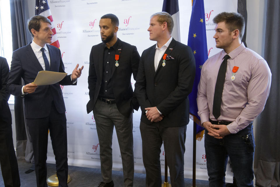 French Consul General Emmanuel Lebrun-Damiens, left, honors Spencer Stone, Anthony Sadler, and Alek Skarlatos during a French Naturalization Ceremony in Sacramento, Calif., Thursday, Jan. 31, 2019. The three men were heralded as heroes when they subdued an armed terrorist on a train in France in 2015. Today they were granted French citizenship. (AP Photo/Randall Benton)