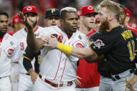 Cincinnati Reds' Yasiel Puig (66) is restrains by Pittsburgh Pirates third baseman Colin Moran (19) during the ninth inning of a baseball game Tuesday, July 30, 2019, in Cincinnati. (AP Photo/John Minchillo)