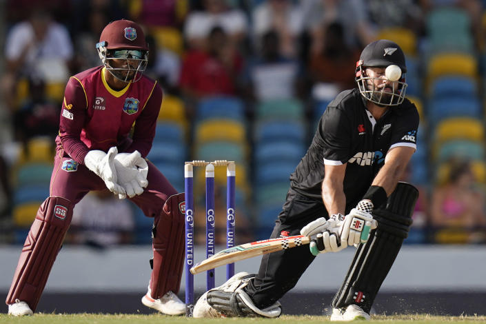 New Zealand's Daryl Mitchell plays a shot under the watch of West Indies keeper Shai Hope during the first ODI at Kensington Oval in Bridgetown, Barbados, Wednesday, Aug. 17, 2022. (AP Photo/Ramon Espinosa)