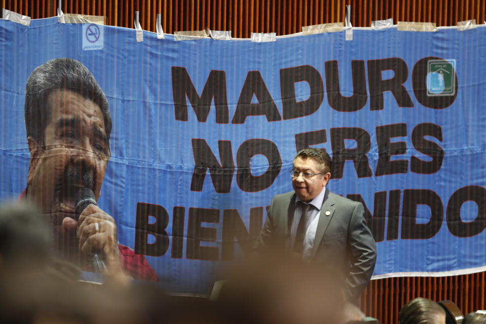 A legislator walks past a banner reading “(Nicolas) Maduro, you’re not welcome” taped to the a wall in the lower house of Congress, just a couple of ours before the Venezuelan leader is scheduled to attend the inauguration of President-elect Andres Manuel Lopez Obrador, at the National Congress in Mexico City, Saturday, Dec 1, 2018. Mexico’s conservative National Action Party has voiced objections to Lopez Obrador’s decision to invite Maduro to the ceremony, because of the economic and political crisis that has marked Maduro’s regime. (AP Photo/Eduardo Verdugo)