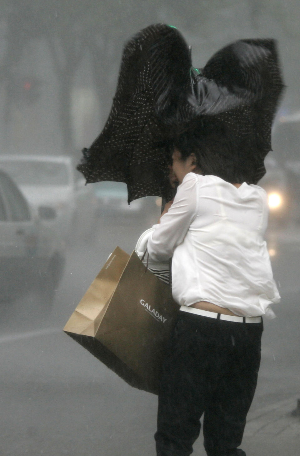 A woman walks in a rainstorm brought on by Typhoon Haikui Wednesday Aug. 8, 2012 in Shanghai, China. The typhoon slammed into eastern China's Zhejiang province early Wednesday, packing winds up to 150 kilometers (90 miles) per hour and triggering flooding. (AP Photo)