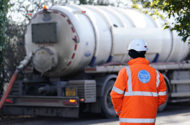 A Thames Water employee in hi-vis watches as a tanker pumps out excess sewage from the Lightlands Lane sewage pumping station in Cookham, Berskhire