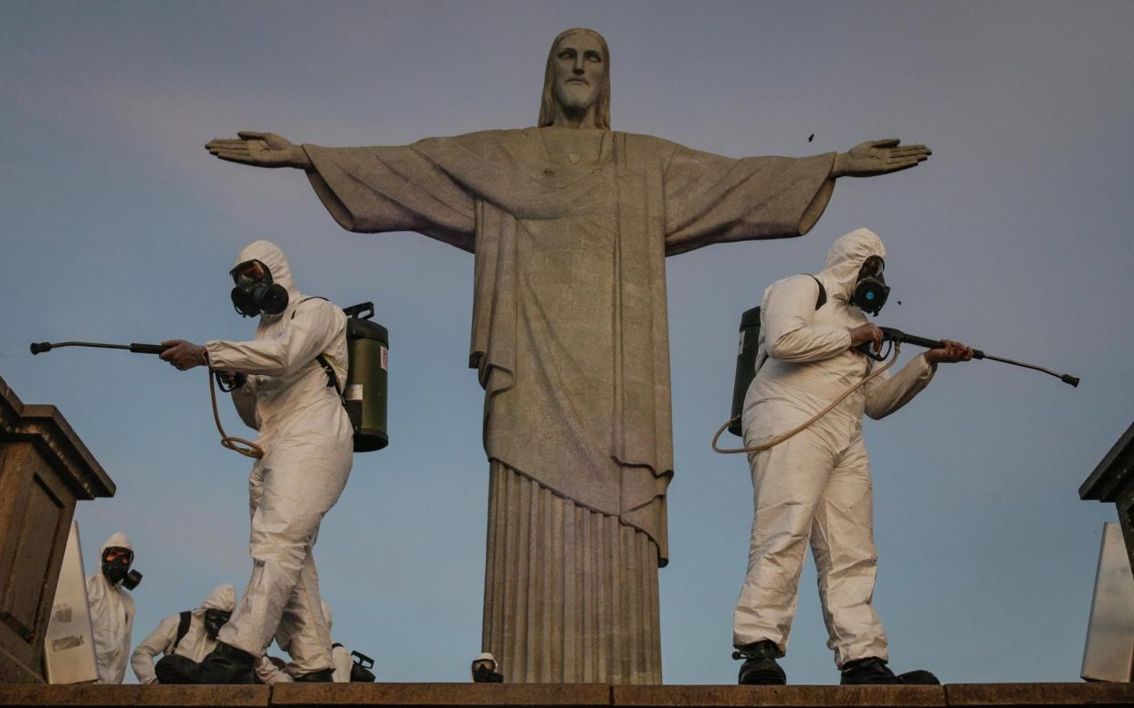 Pictured last year, Brazilian military personnel disinfect the area around Rio de Janeiro's Christ The Redeemer statue - Getty