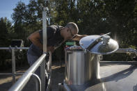 Yousef, an employee of French wine producer MDCV tends to wine production at the bottling facility in the Chateau des Bertrands vineyard in Le Cannet-des-Maures, in the Provence region, Thursday Oct. 10, 2019. European producers of premium specialty agricultural products like French wine, Italian Parmesan and Spanish olives are facing Friday’s U.S. tariff hike with a mix of trepidation and indignation at being dragged into a trade war over the fiercely competitive aerospace industry. (AP Photo/Daniel Cole)
