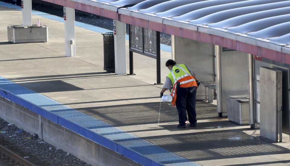 A CTA employee cleans up the platform of a closed off 63rd St. CTA Red Line station following an early morning fatal stabbing on a CTA train in Chicago, Monday, July 25, 2022. (Antonio Perez/Chicago Tribune via AP)