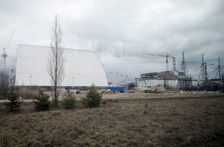 A general view shows a containment shelter for the damaged fourth reactor (R) and the New Safe Confinement (NSC) structure (L) at the Chernobyl Nuclear Power Plant, Ukraine, March 23, 2016. Picture taken through a window. REUTERS/Gleb Garanich