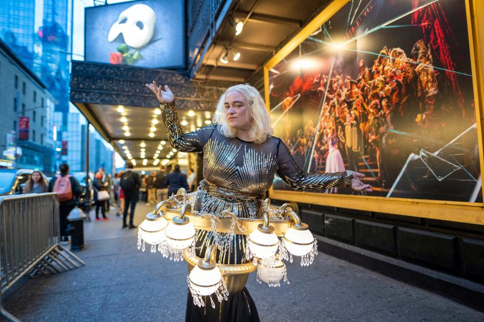 A fan dressed as a chandelier poses outside the Majestic Theatre Sunday night.