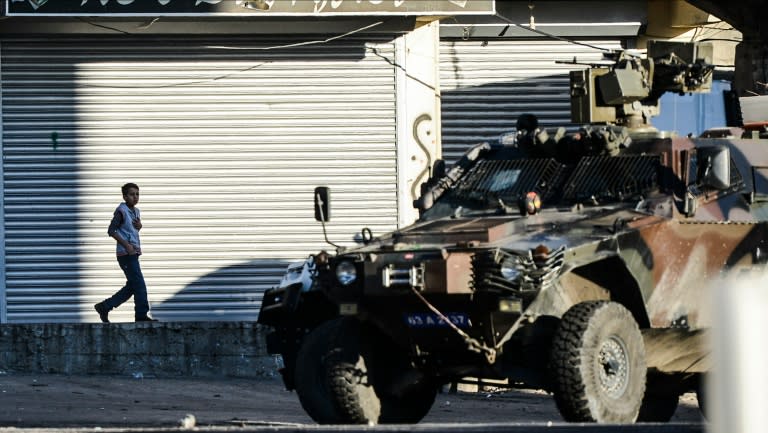 A boy walks past Turkish special forces in Sirnak, southeast Turkey on December 22, 2015 during security operations against Kurdish rebels in the southeastern cities of Cizre and Silopi