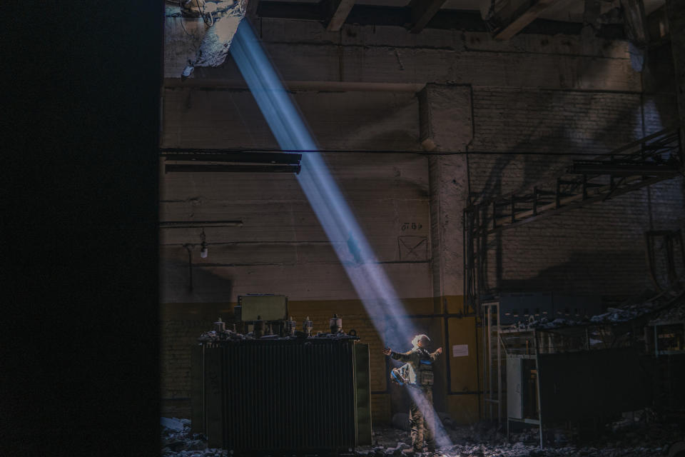 In this photo provided by Azov Special Forces Regiment of the Ukrainian National Guard Press Office, A Ukrainian soldier inside the ruined Azovstal steel plant stands under a sunlight ray in his shelter in Mariupol, Ukraine, May 7, 2022. For nearly three months, Azovstal’s garrison clung on, refusing to be winkled out from the tunnels and bunkers under the ruins of the labyrinthine mill. A Ukrainian soldier-photographer documented the events and sent them to the world. Now he is a prisoner of the Russians. His photos are his legacy.(Dmytro Kozatski/Azov Special Forces Regiment of the Ukrainian National Guard Press Office via AP)