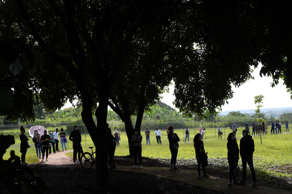 People wait in line for free, rapid COVID-19 tests at a community medical center in Brasilia, Brazil, Thursday, Jan. 13, 2022. Brasilia has registered an increase in the variant omicron. (AP Photo/Eraldo Peres)