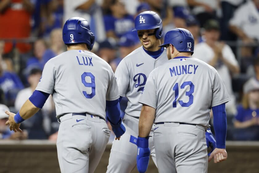Los Angeles Dodgers' Gavin Lux (9) and Max Muncy (13) congratulates Trayce Thompson.