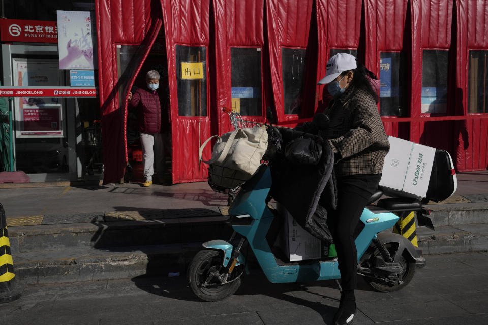 Shoppers leave from a supermarket on Tuesday, March 1, 2022, in Beijing. China's ruling Communist Party is temporarily turning away from its longer-term ambitions to focus on pulling the economy out of a slump as the country heads into the annual meeting of its ceremonial legislature. (AP Photo/Ng Han Guan)