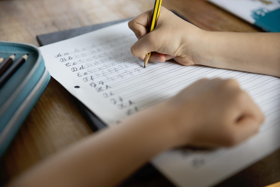 a child practicing cursive letters on a sheet of paper