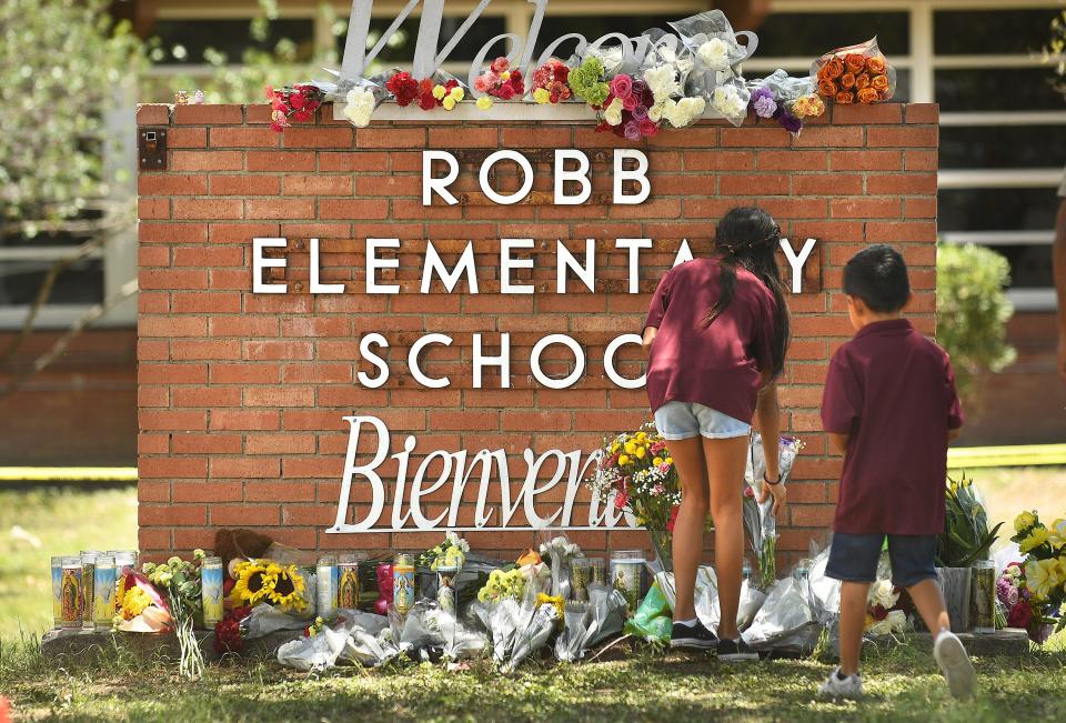 Family members who lost a sibling place flowers outside the Robb Elementary School in Uvalde, Texas last month.