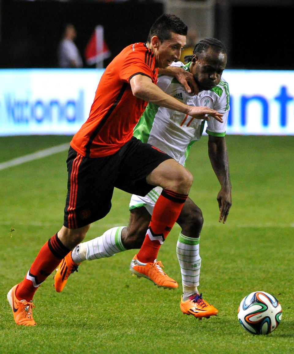 Mexico's Hector Herrera, left, and Nigeria's Victor Moses (11) race for the ball during the first half of an international friendly soccer match Wednesday, March 5, 2014, in Atlanta. (AP Photo/David Tulis)