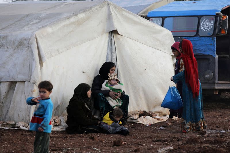 FILE PHOTO: Internally displaced people sit outside tents at a makeshift camp in Azaz