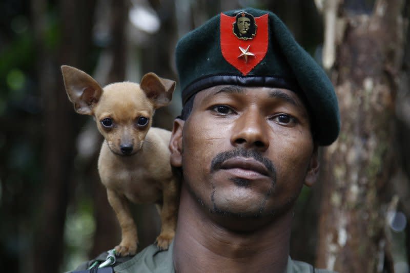 哥倫比亞革命武裝力量人民軍游擊隊員與他的狗合照。（美聯社）
