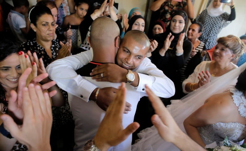 Groom Mahmoud Mansour, 26, (C, facing camera) celebrates with friends and family before his wedding to bride Maral Malka, 23, in Jaffa, south of Tel Aviv August 17, 2014. Israeli police on Sunday blocked more than 200 far-right Israeli protesters from rushing guests at the wedding of a Jewish woman and Muslim man as they shouted "death to the Arabs" in a sign of tensions stoked by the Gaza war. Picture taken August 17, 2014. To match MIDEAST-ISRAEL/WEDDING REUTERS/Ammar Awad