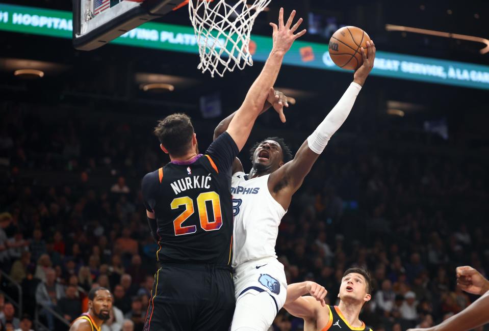 Memphis Grizzlies forward Jaren Jackson Jr. (13) drives to the basket against Phoenix Suns center Jusuf Nurkic (20) in the first half at Footprint Center in Phoenix on Dec. 2, 2023.