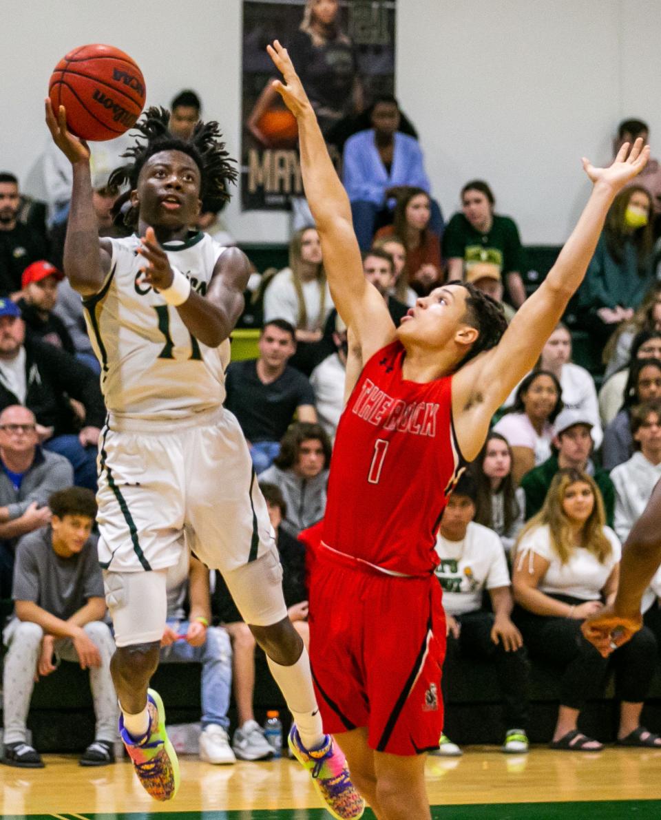 Trinity Catholic's Greg Maxwell shoots over Moses Horne (1) of The Rock. Trinity Catholic defeated The Rock, 65-59, Friday night, Jan. 21, 2022 at Trinity Catholic in Ocala.