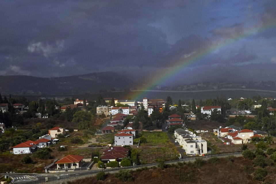 Rainbow appears over the Israeli town of Metula, as seen from the Lebanese side of the Lebanese-Israeli border in the southern village of Kfar Kila, Lebanon, Sunday, Oct. 15, 2023. Sporadic clashes have broken out over the past week along the tense Lebanon-Israel border. (AP Photo/Bilal Hussein)